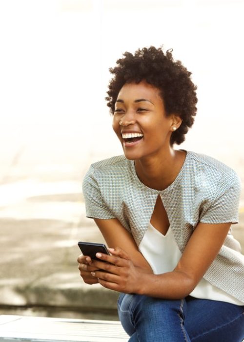 Portrait,Of,Beautiful,Young,African,Woman,Smiling,While,Sitting,Outside