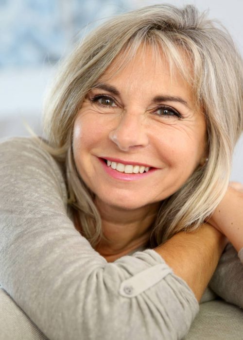 Smiling,Senior,Woman,Sitting,In,Couch,At,Home